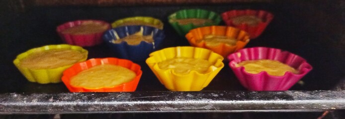 iron tray with uncooked muffins in oven