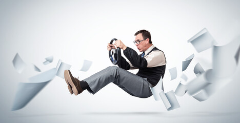 Male office worker with glasses drives a car through flying white paper. Office Roads Concept.
