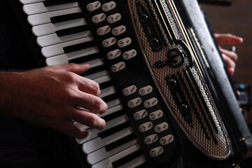 Close up of hands playing accordion in the backlight