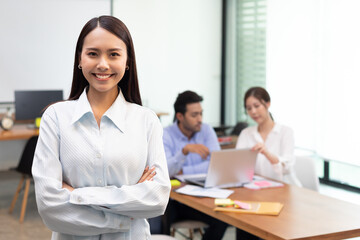 Confident business asian woman stand and cross arm in the office.