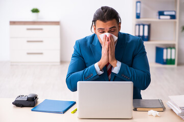 Sick male employee suffering at workplace from coronavirus