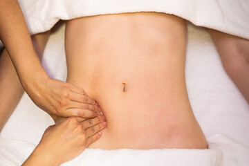 Woman receiving a belly massage in a physiotherapy center.