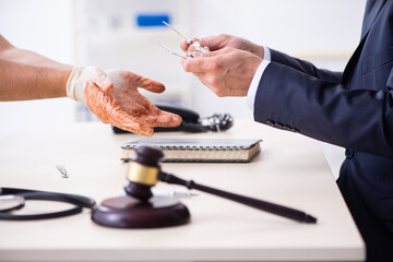 Male doctor in courthouse meeting with advocate