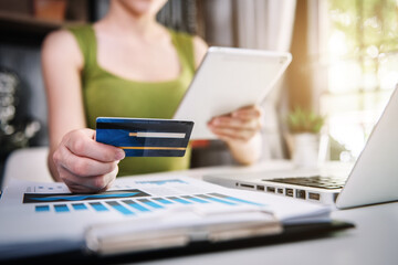 Female use computers and tablet to pay through credit card payment channels. Online shopping Sit at the desk.