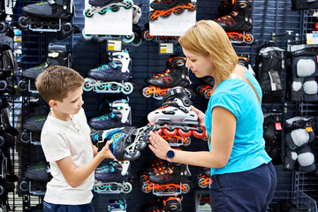 Boy and mother choosing roller skates at sport store