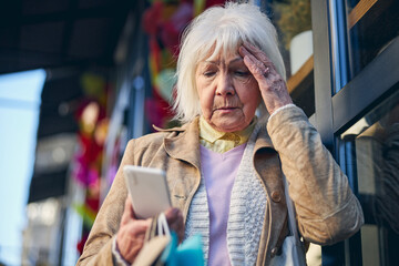 Elderly female reading something in the screen mobile phone