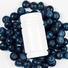 Freshly juicy picked blueberries in medical bottle from pills isolated on white background. 