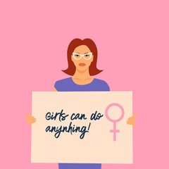 A feminist girl holds a placard reading 