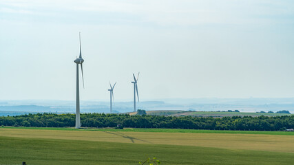 Three wind turbines sit as part of a wind farm in the Pas-de-Calais region of France