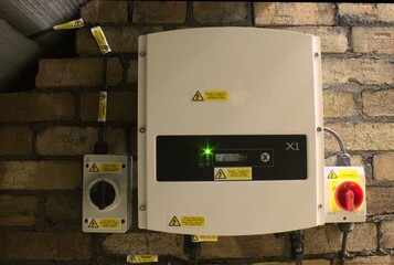 UK Solar power inverter to convert DC solar power to Ac voltage, on the left black switch dc isolator and the red switch on the right is the AC isolator - 365788465