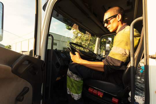 Young truck driver checking the smartphone at work
