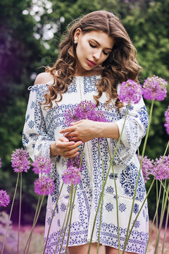 Beautiful woman with long hair among purple flowers