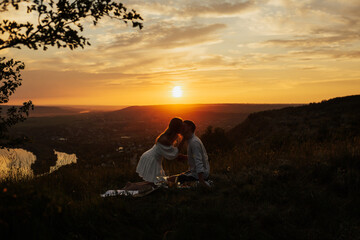 Young couple enjoying a time together in a beautiful sunset. Happy people lifestyle concept. Happy couple on honeymoon kissing. Copy space.