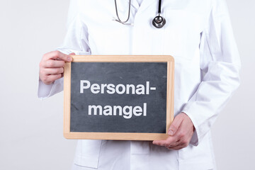 Arzt mit einer Tafel Personalmangel im Krankenhaus oder Arztpraxis
