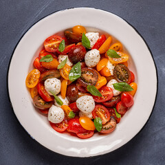 Traditional Caprese salad made of sliced fresh tomatoes, mozzarella cheese and basil