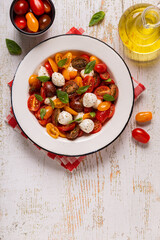 Traditional Caprese salad made of sliced fresh tomatoes, mozzarella cheese and basil