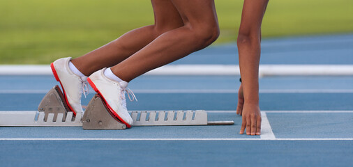 Woman in a starting block on an athletic field