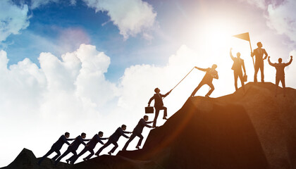 Concept of teamwork with team climbing mountain top
