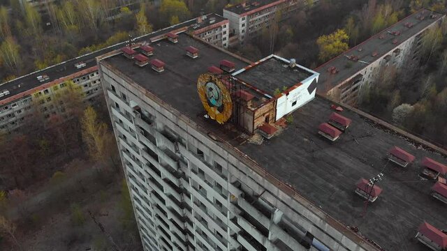 Pripyat aerial panorama cityview over the sign of USSR on the roof of building at sunset. Circling on the drone. Drone flies over the deserted abandoned city of Pripyat, Ukraine.