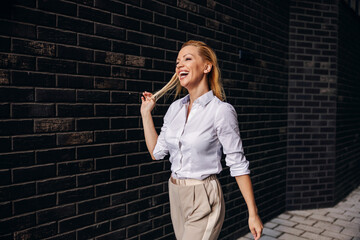 Side view of gorgeous blond fashionable businesswoman walking on the street.