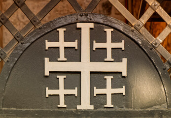 The Jerusalem Cross or Crusaders Cross as part of metal fence in the Old City of Jerusalem in...