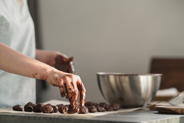 young woman making truffles candy on kitchen