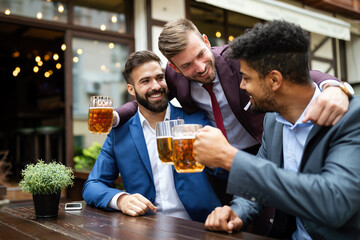 Team of colleagues socializing at the bar and drinking beers