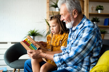 Grandparent enjoy spending time laughing with little girl grandchild at home