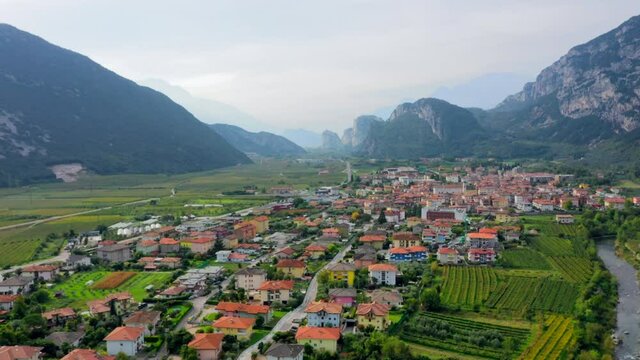 Flying Above Dro Town In Italy with beautiful mountains on the background
