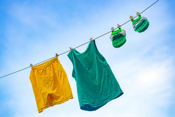 Homemade children's cloth slippers and clothes hung in the sun