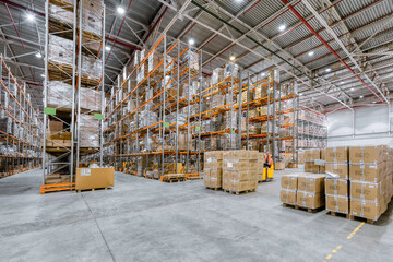 Large industrial warehouse. Many cardboard boxes stand on a loading dock