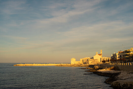 Tourist port of Giovinazzo with defensive walls in the early sunset. Captured taken in the gold hour. Giovinazzo, Metropolitan City of Bari/Apulia (Puglia)/Italy.