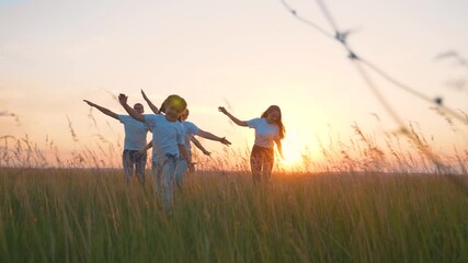 Happy family. Teamwork. A dream of a future flight, vacation, or trip. The silhouette of a running family at sunset with their arms out to the sides. Fantasy game in aviation, the pilot of the plane.