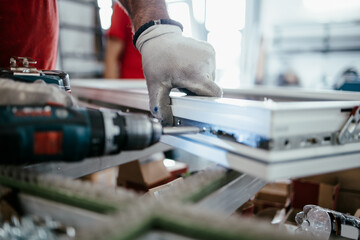 Manual worker assembling PVC doors and windows. Manufacturing jobs. Selective focus. Factory for aluminum and PVC windows and doors production.