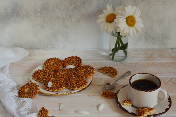 Daisies, homemade cookies, and a cup of coffee on the wooden table. Nice breakfast lifestyle at home