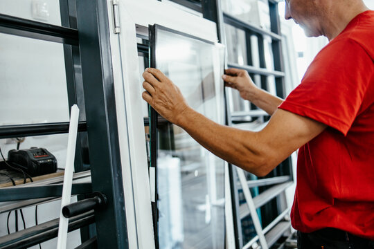 Manual worker assembling PVC doors and windows. Manufacturing jobs. Selective focus. Factory for aluminum and PVC windows and doors production.