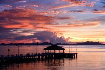 Fototapeta na wymiar Sunset seascape with silhouette bridge.