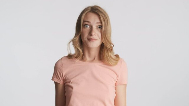 Amazed blond girl throwing up hands thoughtfully looking in camera isolated. I don't know expression