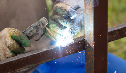 Worker installs a metal fence in the summer.