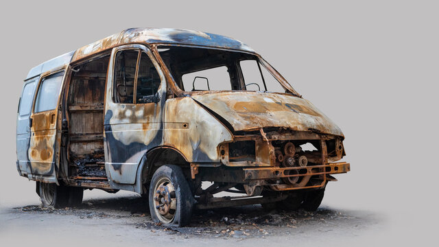 Burnt out delivery van isolated on grey background