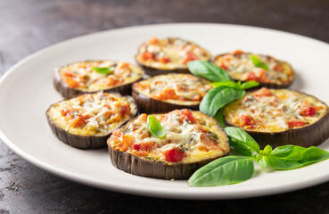 baked eggplant with tomato, basil, pepper and parmesan on a plate - italy