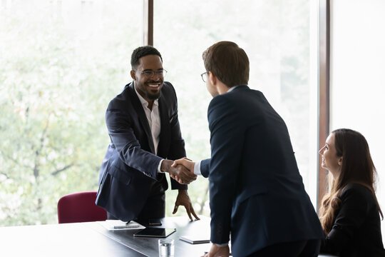 Mixed Race And Caucasian Business Partners Start Group Meeting Shake Hands Express Regard. Happy Candidate Get Hired Job Interview Accomplish. Gesture Of Approval Acceptance, Business Promises Concept