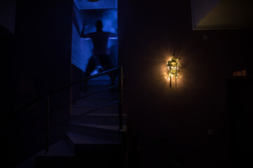 Horror concept. Scary mask with light on the wall inside dark room. Selective focus