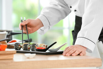 Obraz na płótnie Canvas Handsome Asian chef cooking in kitchen, closeup