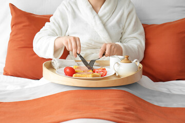 Obraz na płótnie Canvas Young woman having breakfast in hotel room
