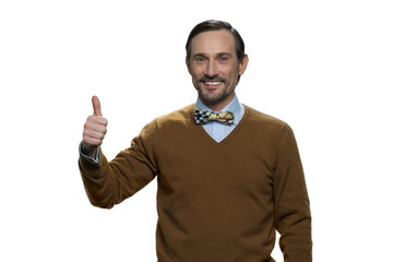 Attractive mature european man with thumb up. Smiling man in brown sweater isolated on white background.