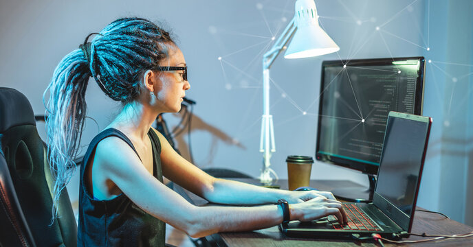 Modern young female programmer is writing program code on a laptop at home. The concept of software development.