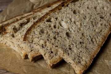 Freshly baked slice of bread sliced ​​on wrapping paper.