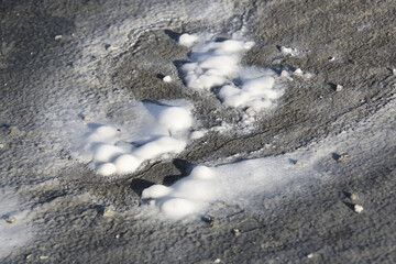 Close-up of the salt pan and mineral crust with red algae of Lake Natron, in the Great Rift Valley, on the border between Kenya and Tanzania. The Rift Valley contains a chain of active volcanoes.