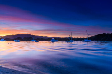 Sunset at the waterfront with high cloud and boats